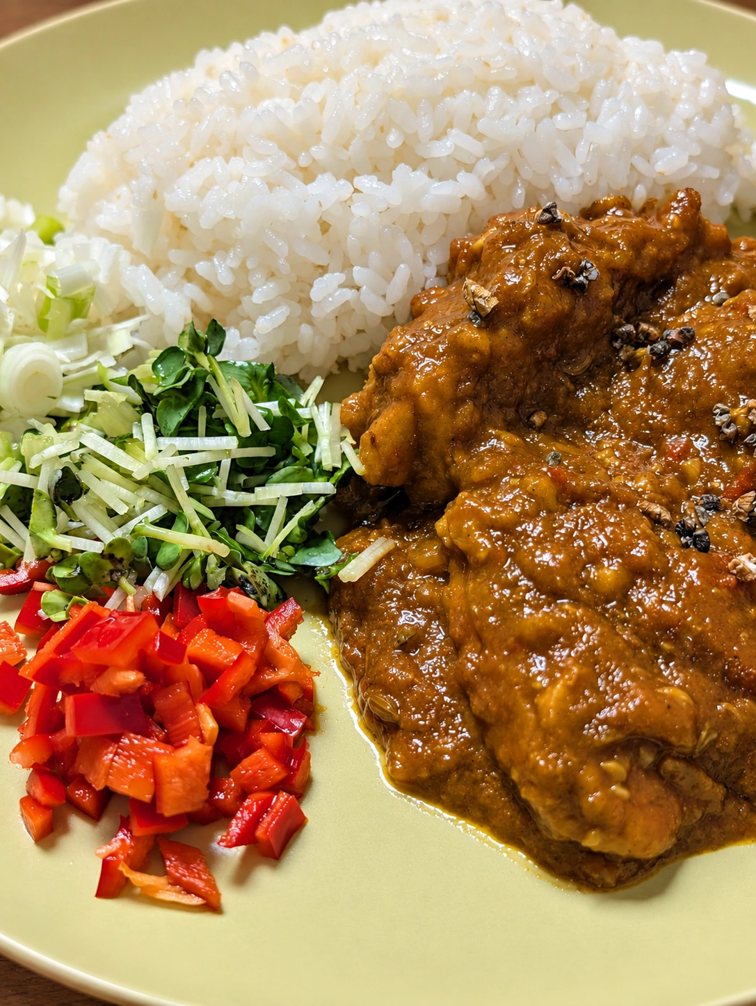 友人特製のカレーとご飯、刻んだ野菜を盛った皿
