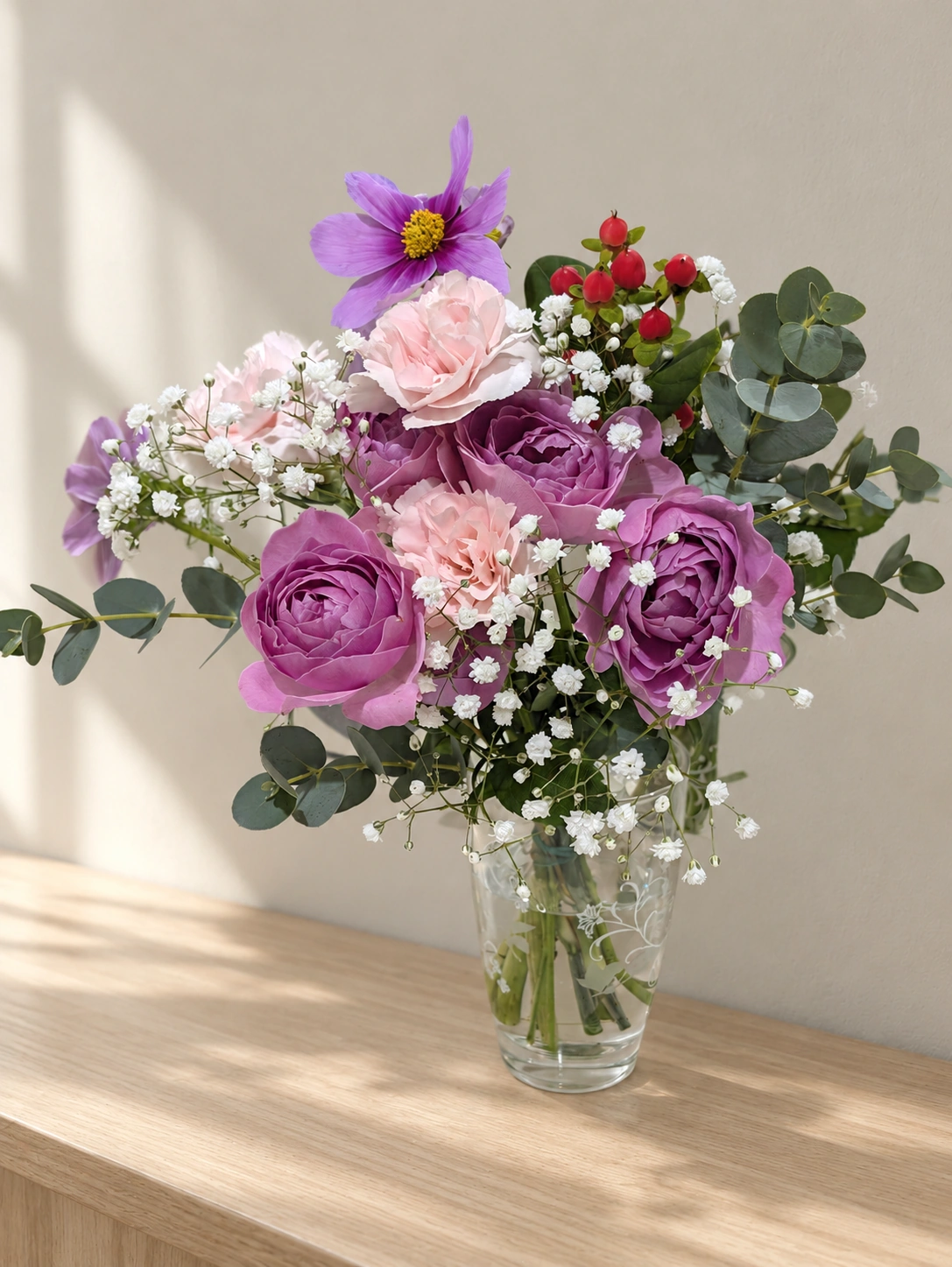 紫とピンクの花束を透明の花瓶に生けた様子(背景などはAIで加工)
