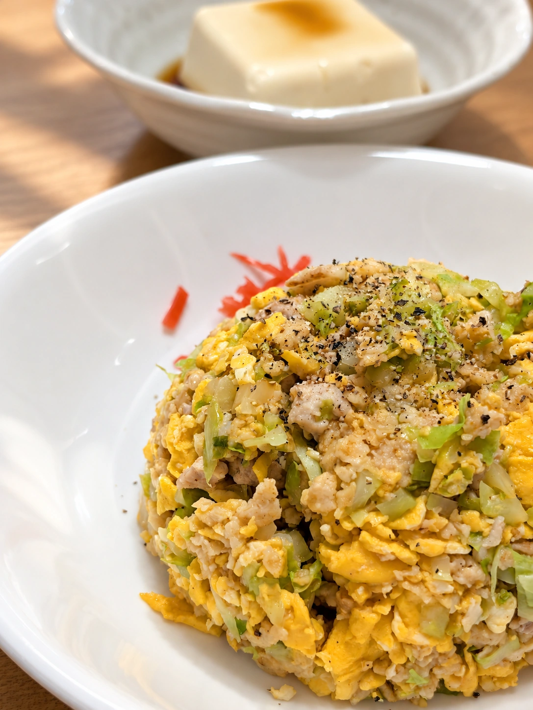 卵と野菜が入ったリュウジレシピのチャーハン(卓上などはAIで加工)