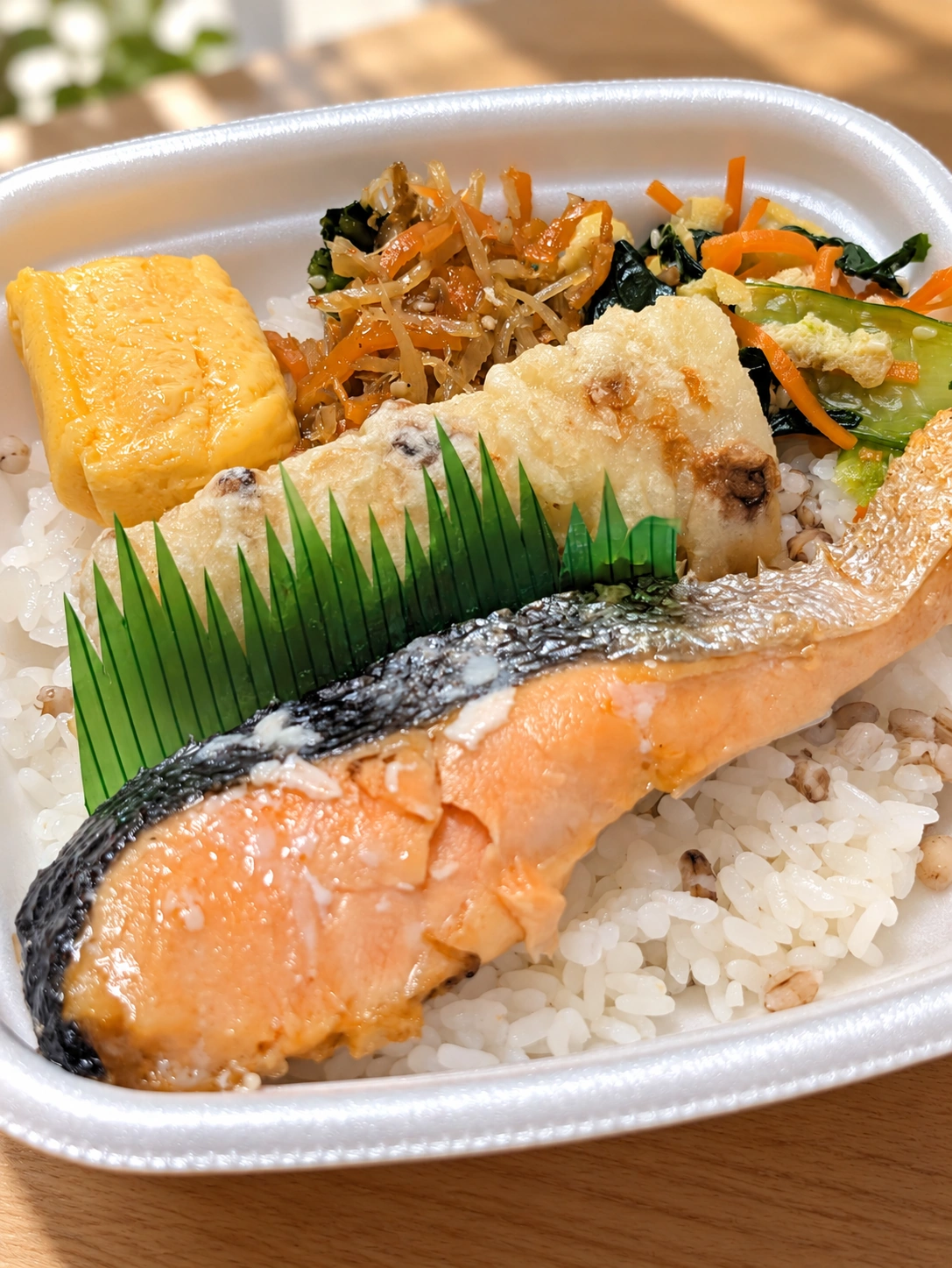 ほっともっとのもちミニしゃけ弁当。鮭、もち麦ごはん、ちくわ天、卵焼きと副菜（背景・光・細部をAIで加工）